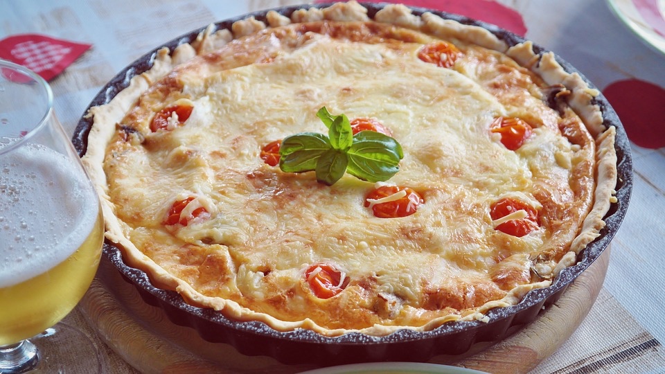 Savoury tart with potatoes, cherry tomatoes, and scamorza cheese 